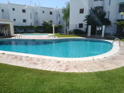 a large swimming pool in a yard with a building at Garden View Vilamoura Apartment in Vilamoura