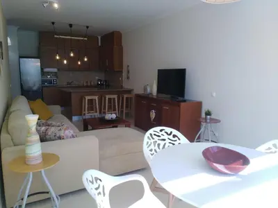 a living room with a couch and a table and chairs at Garden View Vilamoura Apartment in Vilamoura