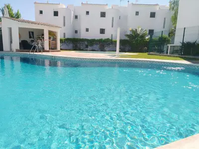 a large blue swimming pool in front of a building at Garden View Vilamoura Apartment in Vilamoura