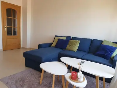 a living room with a blue couch and a table at Oura Beach T1 apartment Coral , close to the Strip, Swimming Pool, Wi Fi, A/C in Albufeira