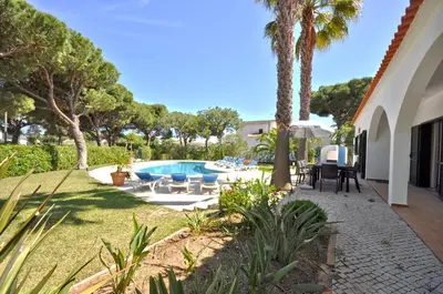 a pool in front of a house with palm trees at Close to Beaches and All Amenities, Private Pool, Free AC and Wifi in Quarteira