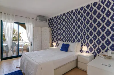 a bedroom with a blue and white patterned wall at Refugio Salgados in Galé