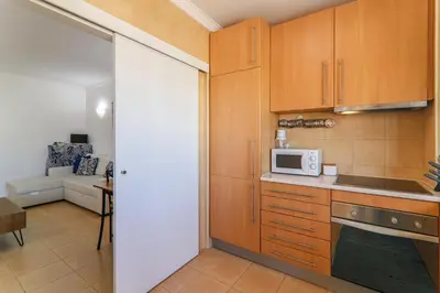 a kitchen with wooden cabinets and a microwave at Refugio Salgados in Galé