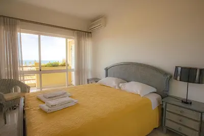 a bedroom with a bed with a yellow blanket and a window at Palmeira Gale - WIFI - Pool - Lux - BY BEDZY in Albufeira