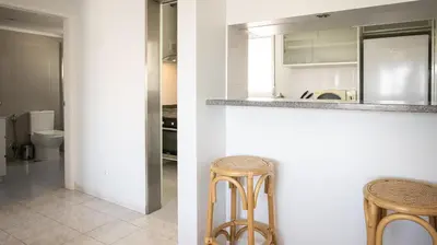 two images of a kitchen with a counter and two stools at Apartamento Palmeira Gale - Beach - Pool - BY BEDZY in Albufeira