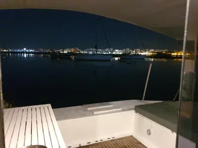 a boat sitting on the water at night at Barco Casa Catamarã Sleepandboat in Faro