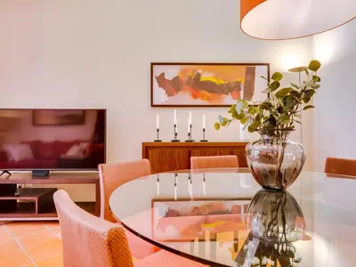 a dining room with a glass table and a vase with flowers at AL - Apartamento Vila Sol F5 AE in Vilamoura