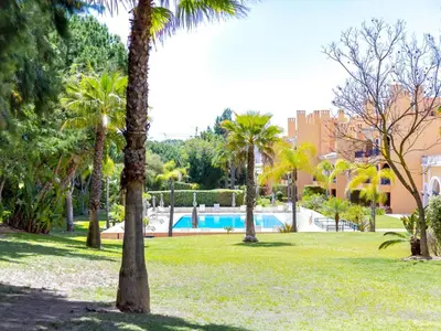 a park with palm trees and a swimming pool at AL - Apartamento Vila Sol F5 AE in Vilamoura