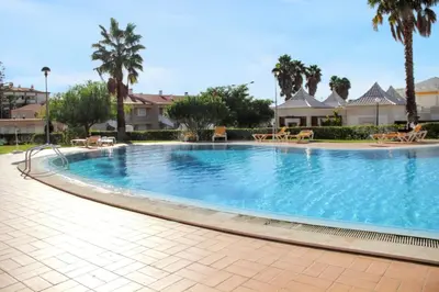 a large swimming pool in a resort with palm trees at Charming Apartment in Vilamoura with Shared Pool - 70 m² in Vilamoura
