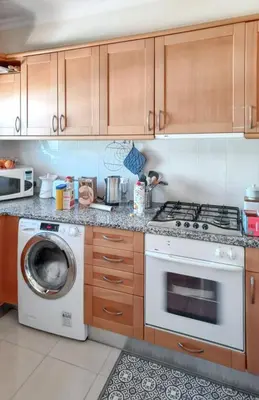 a kitchen with a stove and a washing machine at Charming Apartment in Vilamoura with Shared Pool - 70 m² in Vilamoura