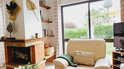 a living room with a fireplace and a chair at Villa charmosa V3 junto à praia e à Marina de Vilamoura in Quarteira