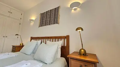 a bedroom with a bed and a lamp on a table at Villa charmosa V3 junto à praia e à Marina de Vilamoura in Quarteira