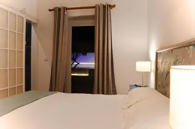 a bedroom with a white bed and a window at 4 Cantos in Faro