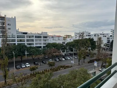 a city street with cars parked in a parking lot at Apartamento Canaima in Quarteira