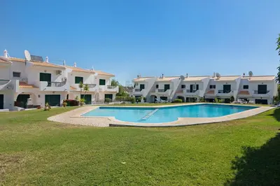 a swimming pool in front of a large building at Villa Janeca in Albufeira