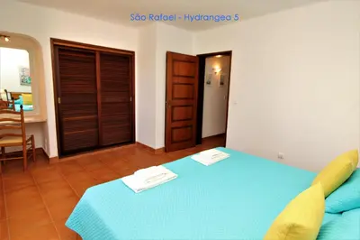 a bedroom with a blue bed and a table at São Rafael - Hydrangea 5, Apt. T2 - Albufeira in Albufeira