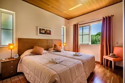 a bedroom with a large bed and two windows at Villa Palm Golfe, fantastic house on Vila Sol course, kids pool, aircon in Quarteira