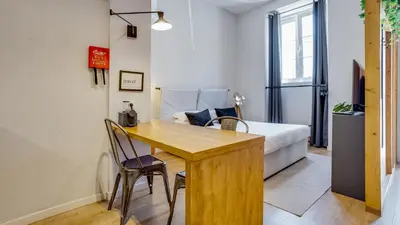 a bedroom with a bed and a wooden table and chairs at Hostellicious Studio in Faro