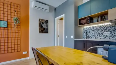 a kitchen with a wooden table and blue cabinets at Hostellicious Studio in Faro