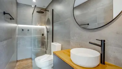 a bathroom with a sink and a toilet and a mirror at Hostellicious Studio in Faro