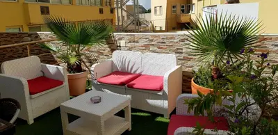 a patio with two chairs and a table and plants at Happy House Comfort Plus in Faro