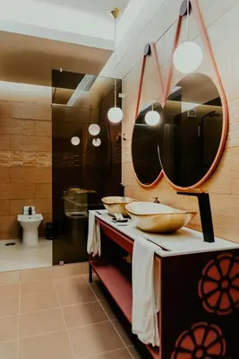a bathroom with two bowls on a counter with mirrors at Happy House Comfort Plus in Faro