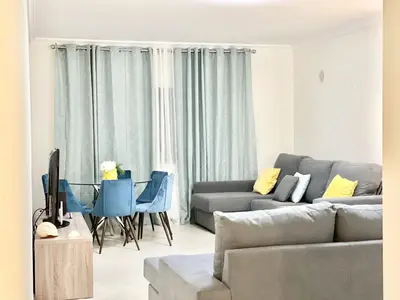 a living room with a couch and a table and chairs at Miral 1 - Apartment 100m to the beach by HD PROPERTIES - Quarteira in Quarteira