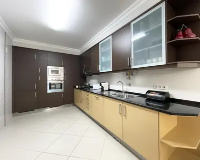 a large kitchen with brown cabinets and a sink at Miral 1 - Apartment 100m to the beach by HD PROPERTIES - Quarteira in Quarteira
