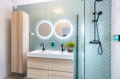 a bathroom with a sink and two mirrors at Casa Primavera in Albufeira