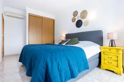 a bedroom with a blue bed and a yellow nightstand at Casa Primavera in Albufeira
