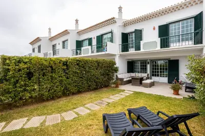 a house with chairs in the yard at Casa Primavera in Albufeira