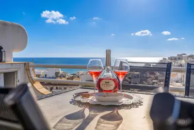 a glass of wine sitting on a table on a balcony at Duplex Sea View by Albufeira Holidays in Albufeira