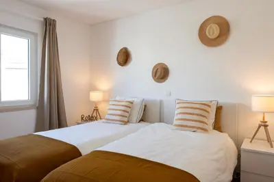 two beds sitting next to each other in a bedroom at Beach villa with ocean view and rooftop cinema in Guia