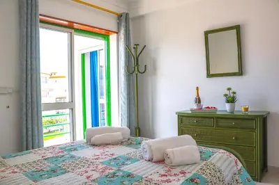 a bedroom with a bed with a dresser and a window at Apartamento Jardim de Sta Eulália in Albufeira