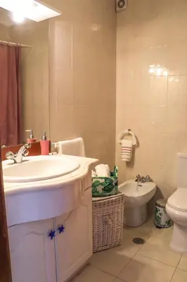 a bathroom with a sink and a toilet and a mirror at Apartamento Jardim de Sta Eulália in Albufeira