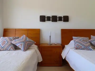 a bedroom with two beds with pillows and a night stand at Happiness Apartment by Stay ici Algarve Holiday Rental in Albufeira