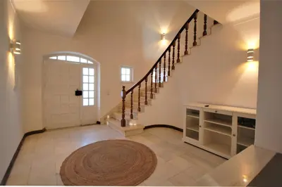 a large hallway with a white door and stairs at Qta do Eucalipto Villa in Faro