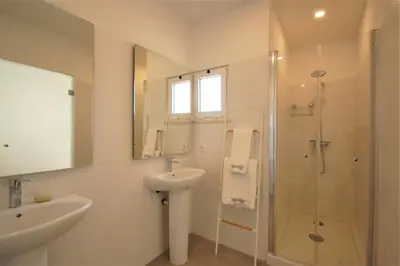 a white bathroom with a sink and a shower at Qta do Eucalipto Villa in Faro