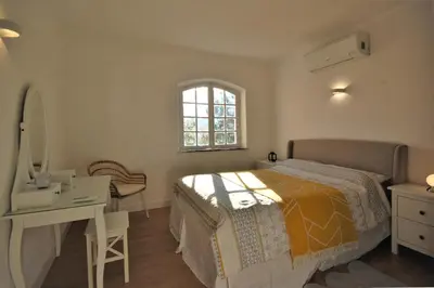 a bedroom with a bed and a desk and a mirror at Qta do Eucalipto Villa in Faro