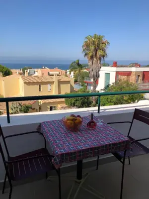 a table with a bowl of fruit on a balcony at Debimar Apartamentos in Albufeira