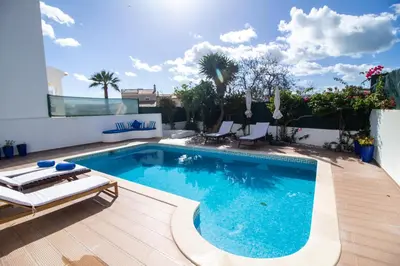 a swimming pool in a backyard with a wooden deck at Villa a Sul in Albufeira