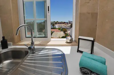 a kitchen with a sink and a window at Oura Sea View by OCvillas in Albufeira