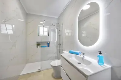 a bathroom with a sink and a toilet and a tub at Villa Goia by Villa Plus in Olhos de Água