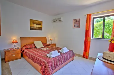 a bedroom with a bed with two towels on it at Villa Jorge by Villa Plus in Albufeira