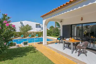 a patio with a table and chairs next to a pool at Villa Jorge by Villa Plus in Albufeira