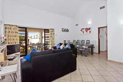 a living room with two couches and a dining room at Villa Neptuno Sol by Villa Plus in Albufeira
