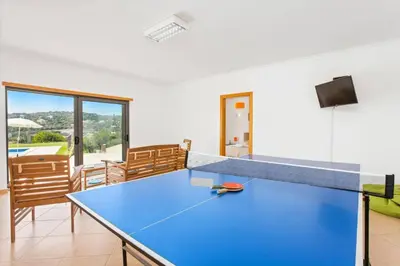 a blue ping pong table in a room at Villa Ribeiro Tomas by Villa Plus in Loulé