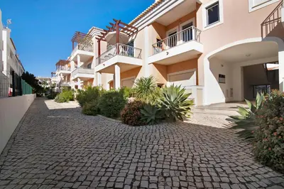 a building with a cobblestone street in front at Apartamento Água Brisa in Albufeira