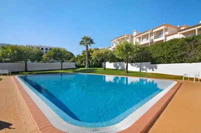 a swimming pool in front of a building at Apartamento Água Brisa in Albufeira