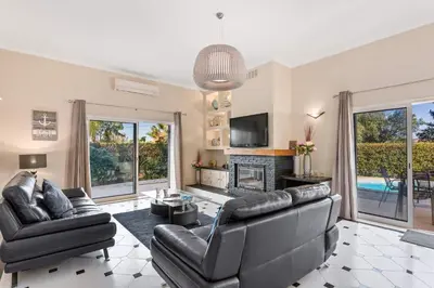 a living room with black leather furniture and a fireplace at Villa Casa do Mel by Villa Plus in Loulé